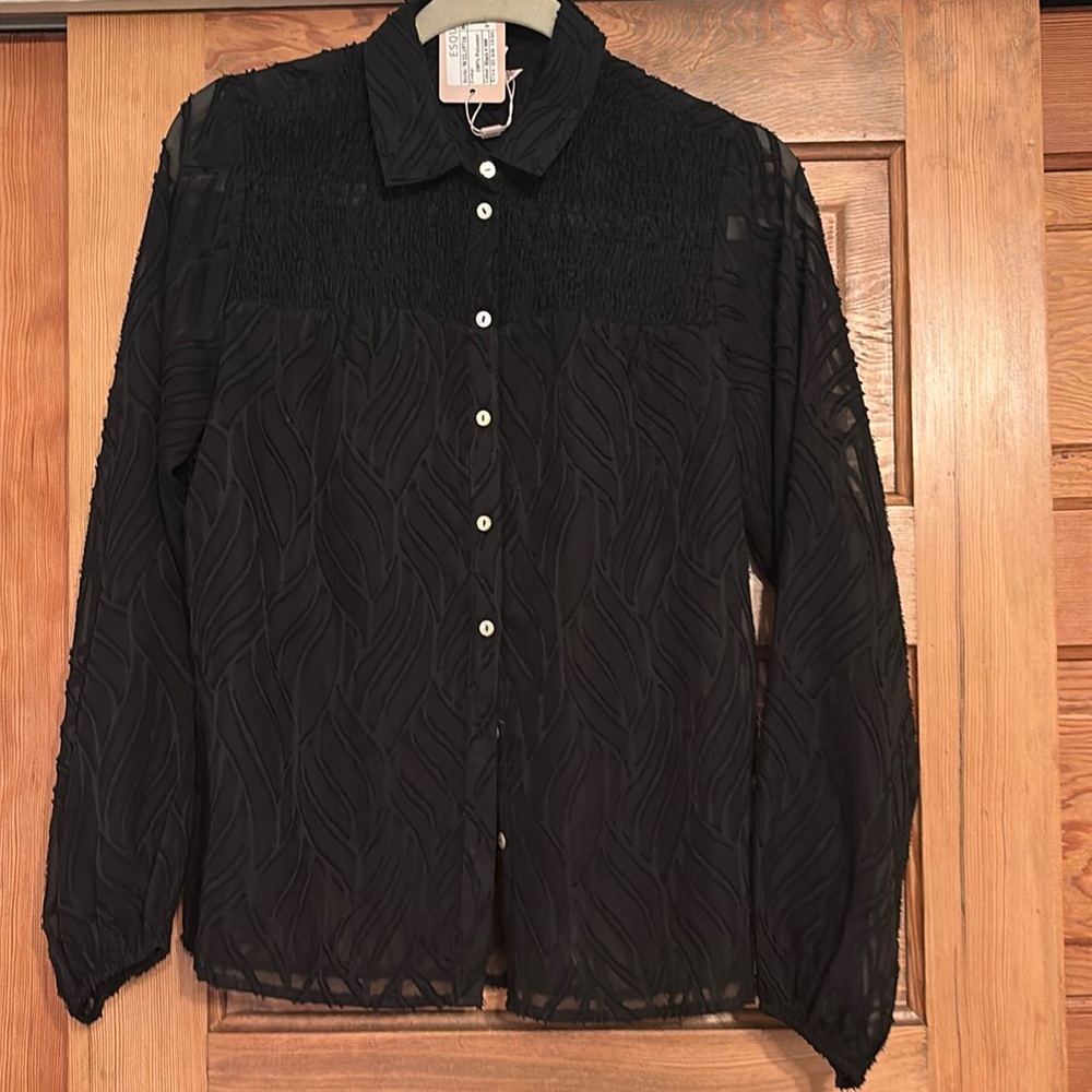 This blouse has an a print similar to an animal print. It is see though black.
